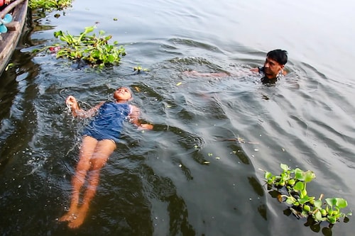 7-year old Jewel Mariam Basil swims across the Vembanadu backwaters, escorted by a medical team, in Alappuzha, Kerala, India on January 8, 2022. Jewel set a record, as the youngest to swim the distance of four kilometres within one hour and forty-five minutes.