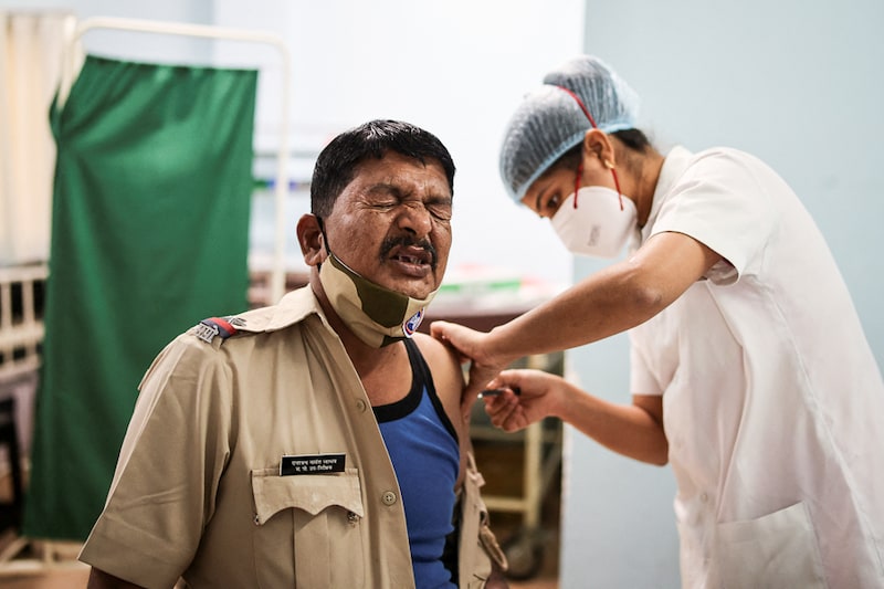 A policeman reacts as he receives a booster dose of the Covishield vaccine against the Covid-19 virus at a vaccination centre in Mumbai, India, January 10, 2022. Precautionary third doses of vaccines are now being given to frontline and health workers and immuno-compromised seniors as Covid cases spike in India, driven by Omicron variant.