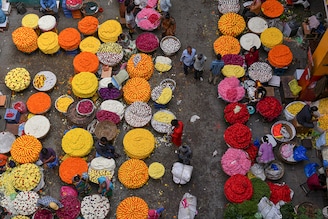 Flower vendors sell garlands in market ahead of the Makar Sankranti harvest festival in Bangalore on January 12, 2022.