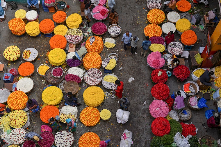 Flower vendors sell garlands in market ahead of the Makar Sankranti harvest festival in Bangalore on January 12, 2022.