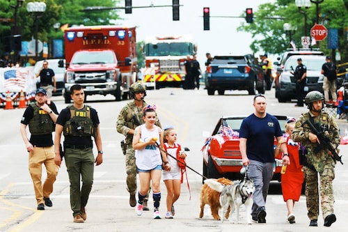 Law enforcement escorts a family away from the scene of a shooting at a Fourth of July parade on July 4, 2022 in Highland Park, Illinois. Police have detained Robert “Bobbyâ€ E. Crimo III, 22, in connection with the shooting in which six people were killed and 19 injured, according to published reports.&nbspImage: Mark Borenstein / Getty Images via AFP