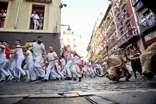 Participants run ahead of bulls during the "encierro" (bull-run) of the San Fermin festival in Pamplona, northern Spain on July 7, 2022.
Image: Miguel Riopa / AFP Participants run ahead of bulls during the "encierro" (bull-run) of the San Fermin festival in Pamplona, northern Spain on July 7, 2022.
Image: Miguel Riopa / AFP