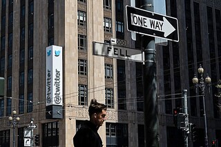 In this file photo taken on April 26, 2022 a person walks past the Twitter headquarters in downtown San Francisco, California. Elon Musk pulled the plug on his deal to buy Twitter on July 8, 2022, accusing the company of "misleading" statements about the number of fake accounts, a regulatory filing showed. Image:&nbspAmy Osborne / AFP