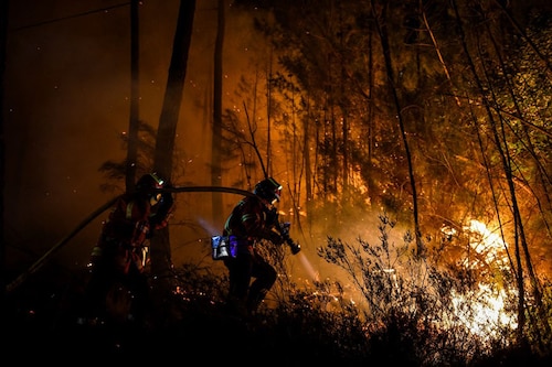 Firefighters spray water to extinguish a wildfire near Besseges, southern France, on July 7, 2022.&nbsp Image:&nbspSylvain Thomas / AFP