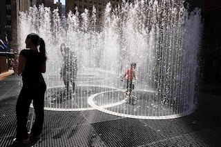 People play in the water-based sculpture of artist Jeppe Hein titled "Changing Spaces" at Rockefeller Center Plaza in New York City on July 19, 2022, as a heat wave continues throughout Europe and North America. Image: Yuki IWAMURA / AFP