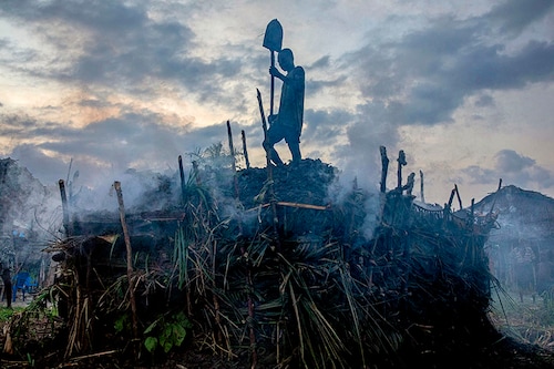 A kiln for making charcoal, widely used for cooking, along a Congo River tributary in Mbandaka, Democratic Republic of Congo, on March 16, 2022. In the Congo River Basin, a rainforest that rivals the Amazon in importance, people who collect bundles of wood to make charcoal play a surprisingly large role in deforestation. (Ashley Gilbertson/The New York Times)