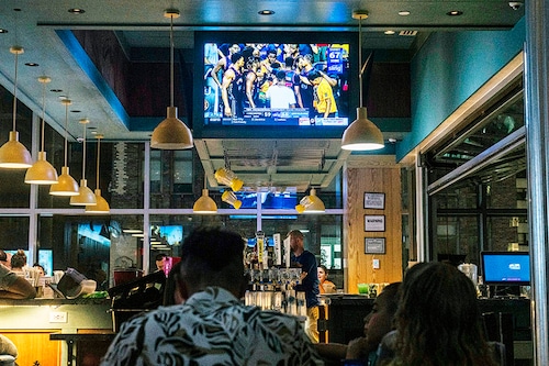 Patrons watch a basketball game at a bar in Manhattan on July 20, 2022. Sports and media executives predict that the NBA will stick with traditional broadcasters after its current agreements expire. (Hiroko Masuike/The New York Times)