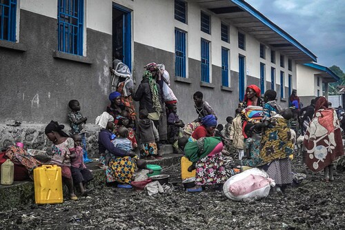 Displaced families from Kibumba take temporary shelter at a school in Kibati, north of Goma, Democratic Republic of Congo on May 24, 2022. Fighting erupted near the city of Goma, a day after neighbouring Rwanda accused the Congolese army of shelling its territory. (Credits: Esdras Tsongo/AFP via Getty Images)