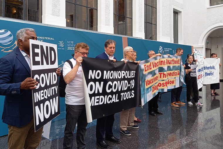 Non-governmental organisation members shout slogans and hold banners as they stage a protest in the World Trade Organization headquarters" central atrium during the second day of a WTO Ministerial Conference in Geneva on June 13, 2022. (Image: Robin MILLARD / AFP)