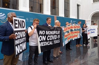 Non-governmental organisation members shout slogans and hold banners as they stage a protest in the World Trade Organization headquarters" central atrium during the second day of a WTO Ministerial Conference in Geneva on June 13, 2022. (Image: Robin MILLARD / AFP)
