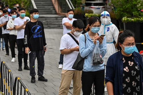 People wait in line for a Covid-19 test on a street in the Jing"an district of Shanghai on June 13, 2022. (Image: Hector RETAMAL / AFP) People wait in line for a Covid-19 test on a street in the Jing"an district of Shanghai on June 13, 2022. (Image: Hector RETAMAL / AFP)