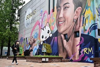 A man walks past a mural depicting RM, a member of K-pop group BTS, in Goyang, northwest of Seoul, on June 15, 2022. (Photo by Anthony WALLACE / AFP)