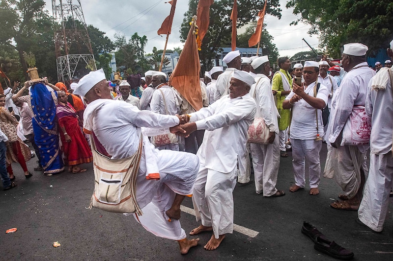 Two warkaris (pilgrims) grip hands and pirouette in joy in Pune on their three-week walk towards Pandharpur on June 22, 2022. After a gap of two years due to pandemic, lakhs of warkaris from across Maharashtra will arrive in Pandharpur on July 10, the day of Ashadhi Ekadashi. Founded by Bhakti saints, the movement is open to all castes and religions, and makes no discrimination towards women, an equality that has had a widespread impact on Maharashtra to date.