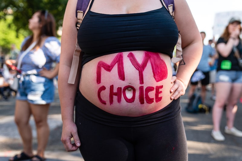 A slogan in bold on an abortion rights demonstrator"s body, seen outside the US Supreme Court in Washington DC, on Saturday, June 25, 2022. The US Supreme Court overturned the 1973 Roe v. Wade decision on Friday and wiped out the constitutional right to abortion, issuing a historic ruling likely to render the procedure largely illegal in half the country.