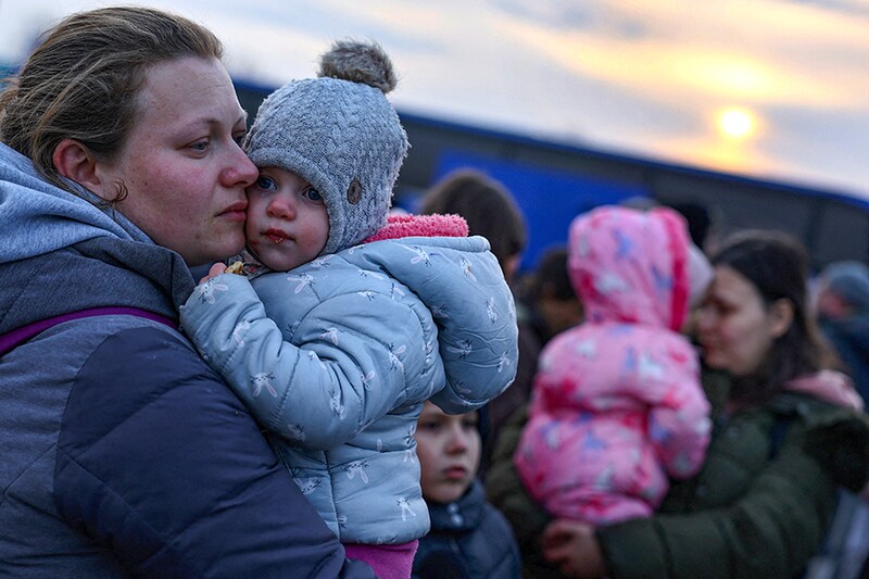 Ukrainian women fleeing the Russian invasion hold their children as they arrive at a temporary camp in Przemysl, Poland, on March 1, 2022. This conflict between Russia and Ukraine has created one of the biggest migration crises in Eastern Europe.