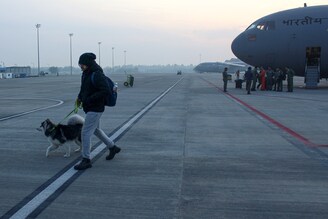 An Indian student disembarks with his pet husky, arriving on an Indian Air Force C-17 Globemaster at the Hindon Air Base in Ghaziabad, India on March 3, 2022.