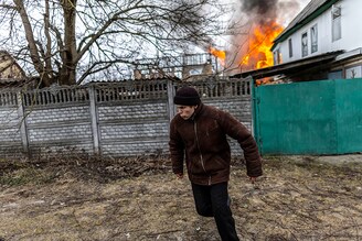 A local resident reacts as a house catches fire after heavy shelling on the only escape route used by locals in Irpin, 24km from Kyiv, as Russian troops advance toward the capital on March 6, 2022.