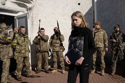 Yelena Lavinska, 22, holds a photo of her fiancé, Mikhailo Pristupa, a Ukrainian soldier who was shot and killed in Irpin on March 5, during his wake and funeral at Baikove Cemetery in Kyiv, Ukraine, March 10, 2022. (Lynsey Addario/The New York Times) Yelena Lavinska, 22, holds a photo of her fiancé, Mikhailo Pristupa, a Ukrainian soldier who was shot and killed in Irpin on March 5, during his wake and funeral at Baikove Cemetery in Kyiv, Ukraine, March 10, 2022. (Lynsey Addario/The New York Times)