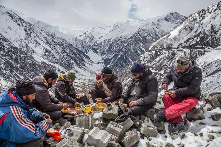 Kashmiri labourers clearing snow take a lunch break near Zojila Pass, after the 434-km-long Srinagar-Leh highway was reopened to traffic on March 19, 2022. One of Kashmir"s most treacherous mountain passes that connects it with Ladakh, the strategic Zojila Pass was reopened after 73 days, a record compared to an average closure of 135 days in previous years.