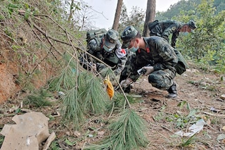 Paramilitary police officers conducting a search at the site of the China Eastern Airlines plane crash in Tengxian county, Wuzhou city, in China"s southern Guangxi region.Â 
Image : CNS / AFP