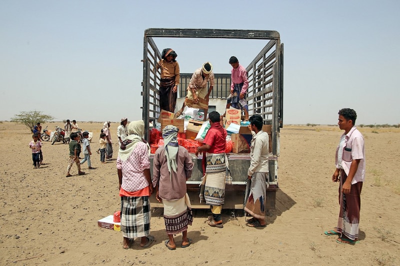 Displaced Yemenis in conflict zone receive food aid and supplies at a camp in war-ravaged western province of Hodeidah on March 29, 2022. Ukraine supplies nearly a third of Yemen"s wheat imports, evoking fears of a deepening famine. The disruption in export flows has spurred fears of a global hunger crisis, especially across the Middle East and Africa.