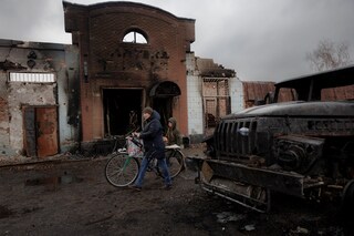 A resident walks past a burned out building after Ukrainian forces expelled Moscow"s troops from the the town of Trostyanets which they had occupied at the beginning of their war with Ukraine, March 30, 2022. (Credit: Thomas Peter / Reuters)