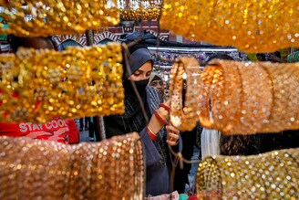 A woman checks bangles on display at a market ahead of the Eid al-Fitr festival, which marks the end of the Muslim fasting month of Ramadan, in Kolkata, India on May 1, 2022.