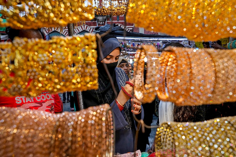 A woman checks bangles on display at a market ahead of the Eid al-Fitr festival, which marks the end of the Muslim fasting month of Ramadan, in Kolkata, India on May 1, 2022.