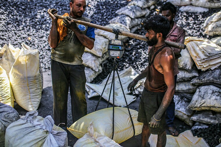 Workers weigh a sack of coal at a coal wholesale market in Mumbai, India, on Thursday, May 5, 2022. Production of coal, the fossil fuel that accounts for more than 70 percent of India"s electricity generation, has failed to keep pace with unprecedented energy demand from the heatwave and the country"s post-pandemic industrial revival.