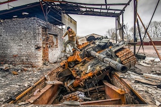 A man jumps from a Russian T-72 tank destroyed during Russia"s invasion, in the village of Yahidne, Ukraine April 20, 2022.  REUTERS/Vladyslav Musiienko