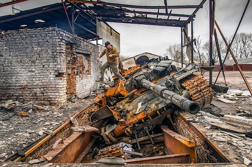 A man jumps from a Russian T-72 tank destroyed during Russia"s invasion, in the village of Yahidne, Ukraine April 20, 2022.  REUTERS/Vladyslav Musiienko