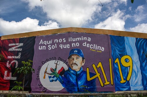 A mural depicting president Daniel Ortega in EstelÃ­, Nicaragua, on July 2, 2021. The slogan at top is a quotation from the 19th century Nicaraguan poet RubÃ©n Dario and reads “Here we are illuminated by a sun that does not decline.â€ (Inti Ocon/The New York Times)