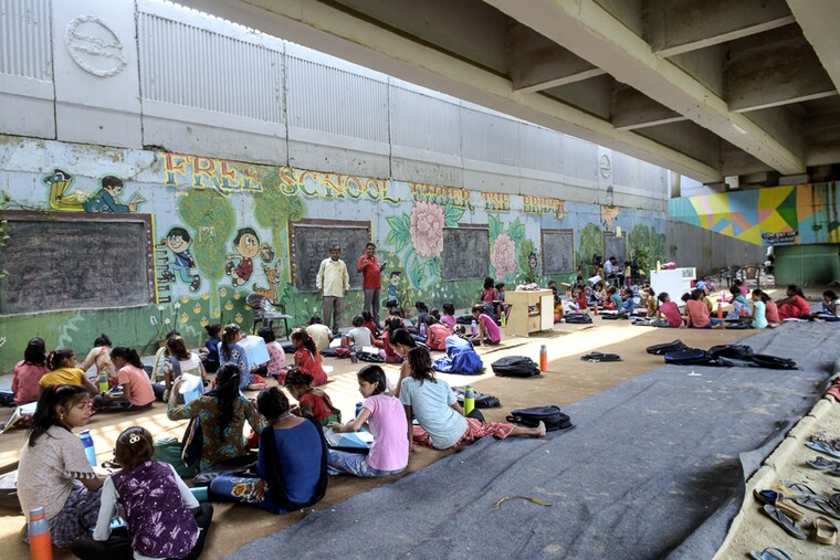 The intense summer heat is no deterrent for these children at an open-air makeshift school under a metro bridge in New Delhi India, May 06, 2022. The free school underneath the metro bridge is run by a group of undergraduate students for children who come from the slums situated adjacent to the Yamuna river.