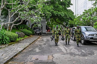 Members of Sri Lankan security personnel walk inside Sri Lanka"s outgoing prime minister Mahinda Rajapaksa"s official residence "Temple Trees", a day after it was breached by the protesters in Colombo on May 10, 2022. Sri Lanka deployed thousands of troops and police on May 10 to enforce a curfew after five people were killed in the worst violence in weeks of protests over an unprecedented economic crisis.
