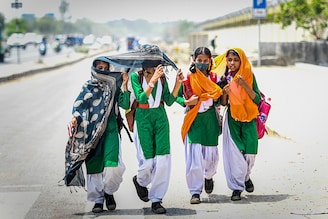 Schoolchildren are seen with their faces covered due to the scorching heat, at Majlis Park on May 12, 2022, in New Delhi, India. Officials of the India Meteorological Department (IMD) said heatwave conditions are likely to be declared over the National Capital Region with a yellow alert in place for Friday and Saturday.