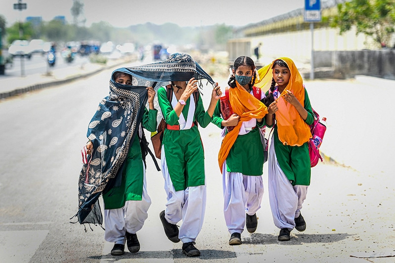 Schoolchildren are seen with their faces covered due to the scorching heat, at Majlis Park on May 12, 2022, in New Delhi, India. Officials of the India Meteorological Department (IMD) said heatwave conditions are likely to be declared over the National Capital Region with a yellow alert in place for Friday and Saturday.