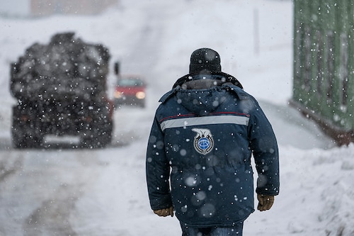 A man wearing an anorak with the logo of Arktikugol company on the back walks in the blizzard on May 7, 2022, in the miners" town of Barentsburg, on the Svalbard Archipelago, northern Norway.​ (Credits: Jonathan NACKSTRAND / AFP) A man wearing an anorak with the logo of Arktikugol company on the back walks in the blizzard on May 7, 2022, in the miners" town of Barentsburg, on the Svalbard Archipelago, northern Norway.​ (Credits: Jonathan NACKSTRAND / AFP)