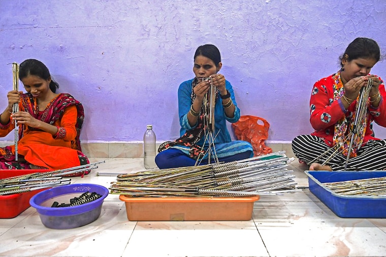 Visually impaired women make umbrellas at a workshop run by NGO Nethra under the aegis of the National Association Of Disabled Enterprises in Mumbai on May 23, 2022. The total population of blind women in India is estimated at 15 million, and only 5 percent of them have vocational opportunities to make them capable of earning.
