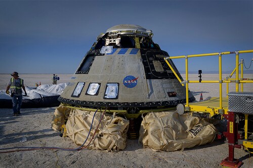 In this handout image courtesy of NASA, Boeing and NASA teams work around Boeing’s CST-100 Starliner spacecraft after it landed at White Sands Missile Range’s Space Harbor, May 25, 2022, in New Mexico. Boeing"s Starliner capsule returned to Earth Wednesday in the final step of a key uncrewed test flight to prove itself worthy of providing rides for NASA astronauts to the International Space Station. (Credits: Bill INGALLS / NASA / AFPâ€‹)