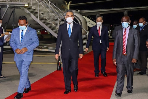 This picture taken on May 25, 2022, shows Solomon Island"s Foreign Minister Jeremiah Manele (L) and Chief Protocole Walter Diamana (R) escorting Chinese Foreign Minister Wang Yi (C) upon his arrival at the Henderson International Airport in Honiara. Image: STRINGER / AFP
