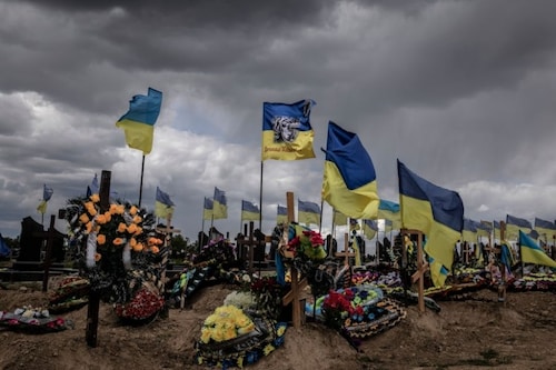 Ukrainian flags fly above graves at the military cemetery in Kharkiv, Ukraine, May 17, 2022. Differing objectives foreshadow a coming debate about what position President Volodymyr Zelenskky of Ukraine and his Western allies would take if negotiations to end the conflict finally get going. Image: Finbarr O"Reilly/The New York Times