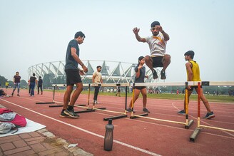 Athletes train at Jawaharlal Nehru Stadium on a smoggy morning on November 3, 2022, in New Delhi, India. The thick toxic smog blanketed the Jawaharlal Nehru Stadium even as the athletes went about their training there. Some jogged and some sprinted on the track as the air quality dipped to severe levels in the national capital on Thursday (AQI of 449 at JLN stadium). Many stopped after a brief run while some were seen coughing.