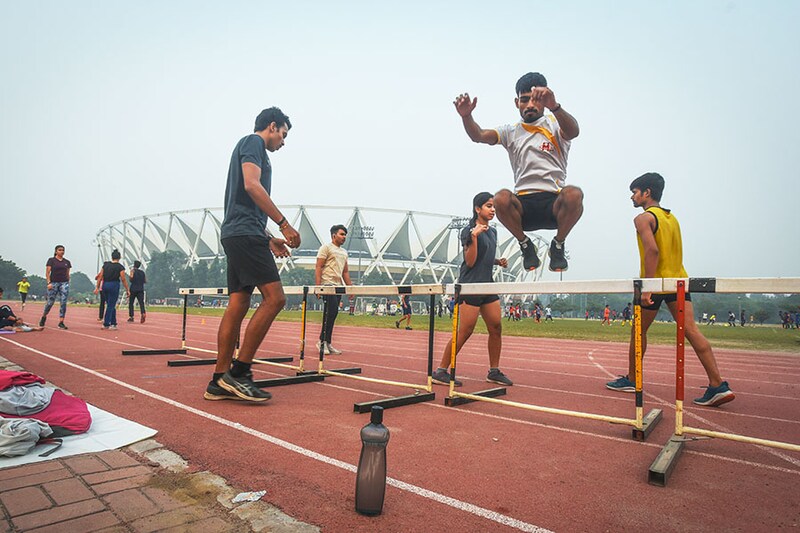 Athletes train at Jawaharlal Nehru Stadium on a smoggy morning on November 3, 2022, in New Delhi, India. The thick toxic smog blanketed the Jawaharlal Nehru Stadium even as the athletes went about their training there. Some jogged and some sprinted on the track as the air quality dipped to severe levels in the national capital on Thursday (AQI of 449 at JLN stadium). Many stopped after a brief run while some were seen coughing.