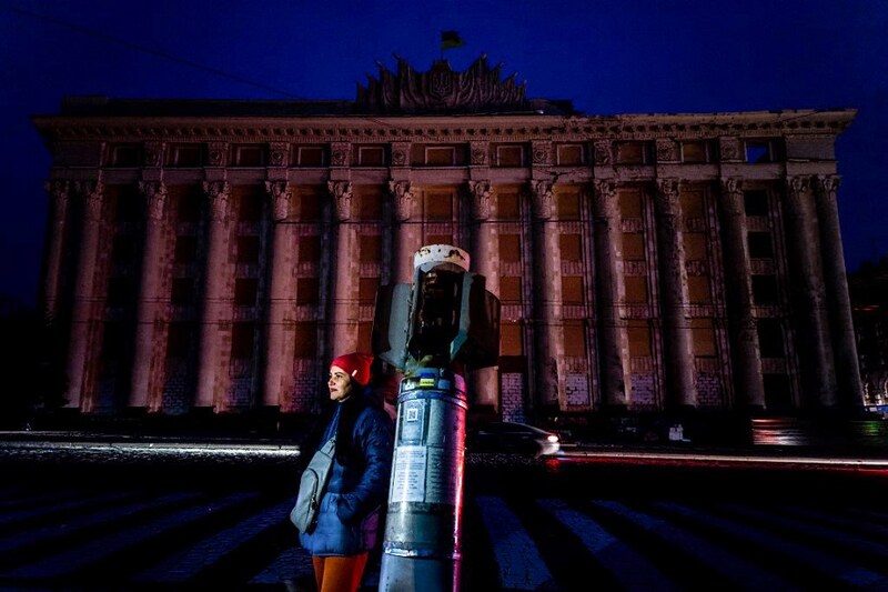 A woman stands in the dark square in front of damaged building of the Kharkiv Regional State Administration on November 5, 2022, amid Russia"s military invasion on Ukraine. Ukraine"s state energy company on November 5, 2022 announced additional power rationing in Kyiv and several other regions of the country following scheduled electricity cuts already imposed to limit the consumption, following Russian strikes.