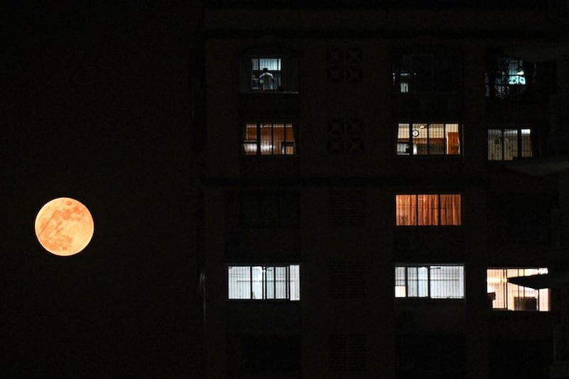The "Blood Moon" rises after a lunar eclipse near a residential building in Mumbai on November 8, 2022. This was the last total lunar eclipse until 2025 and the next such eclipse visible from India will take place on September 7, 2025.