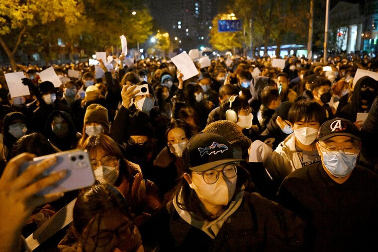 Protesters march along a street during a rally for the victims of a deadly fire as well as a protest against China"s harsh Covid-19 restrictions in Beijing on November 28, 2022. A deadly fire on November 24, 2022, in Urumqi, the capital of northwest China"s Xinjiang region, has become a fresh catalyst for public anger, with many blaming Covid-19 lockdowns for hampering rescue efforts, as hundreds of people took to the streets in China"s major cities on November 27, 2022, to protest against the country"s zero-Covid policy in a rare outpouring of public anger against the state. Authorities deny the claims.