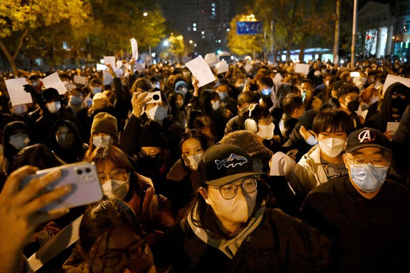 Protesters march along a street during a rally for the victims of a deadly fire as well as a protest against China"s harsh Covid-19 restrictions in Beijing on November 28, 2022. A deadly fire on November 24, 2022, in Urumqi, the capital of northwest China"s Xinjiang region, has become a fresh catalyst for public anger, with many blaming Covid-19 lockdowns for hampering rescue efforts, as hundreds of people took to the streets in China"s major cities on November 27, 2022, to protest against the country"s zero-Covid policy in a rare outpouring of public anger against the state. Authorities deny the claims.