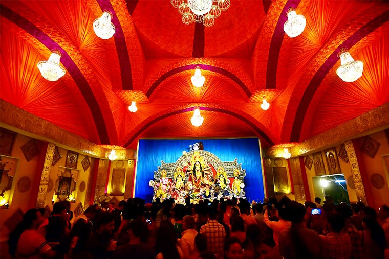 Devotees gather in a pandal to offer prayers to the idol of goddess Durga during the "Durga Puja" festival in Prayagraj on October 2, 2022.
