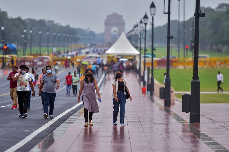 Commuters out in the rain on Kartavya Path (formerly Rajpath) near India Gate, on October 7, 2022 in New Delhi, India.