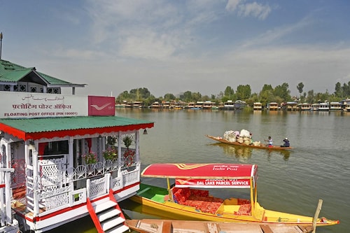 A man steers his boat past a floating post office at the Dal Lake in Srinagar on October 12, 2022.